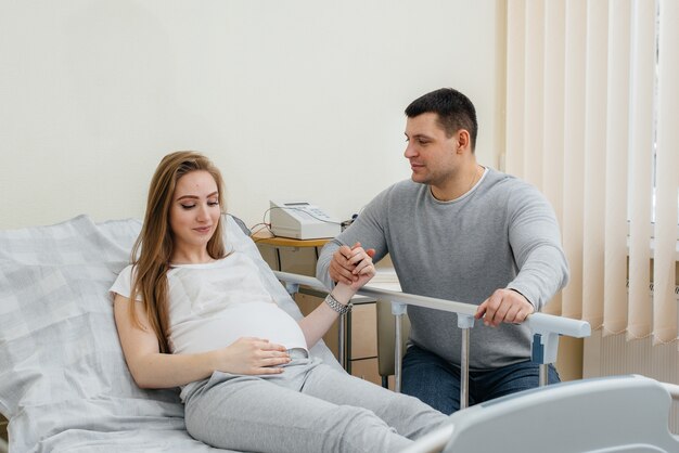 Mujer embarazada en la clínica para consulta con el futuro padre. Examen medico