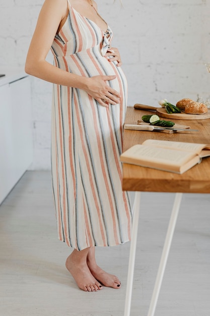 Mujer embarazada cocinando en una cocina