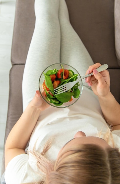 Una mujer embarazada come una ensalada con verduras Enfoque selectivo