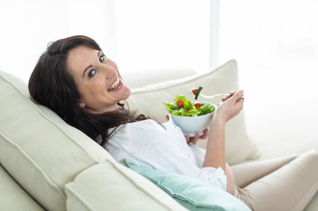 Mujer embarazada, comida, ensalada, en, sofá