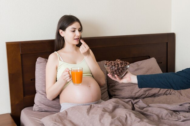 Mujer embarazada comiendo bolas de cereal de chocolate