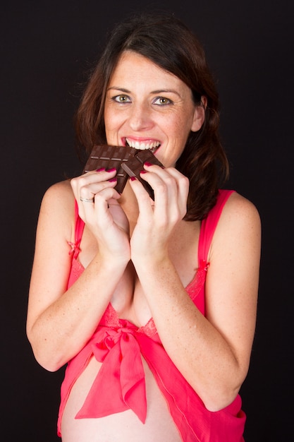 Foto mujer embarazada comiendo chocolate