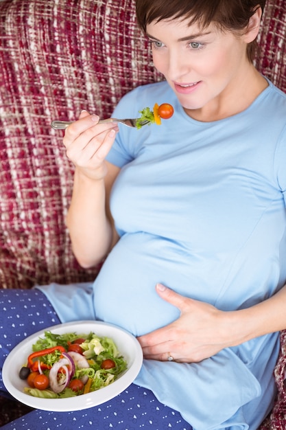 Mujer embarazada comiendo una ensalada