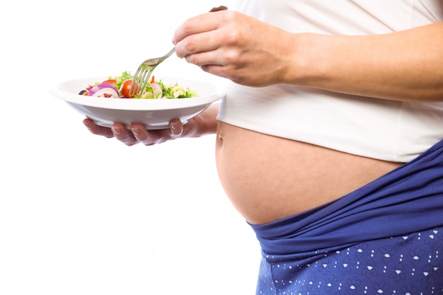 Mujer embarazada comiendo una ensalada