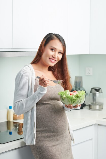 Mujer embarazada comiendo ensalada