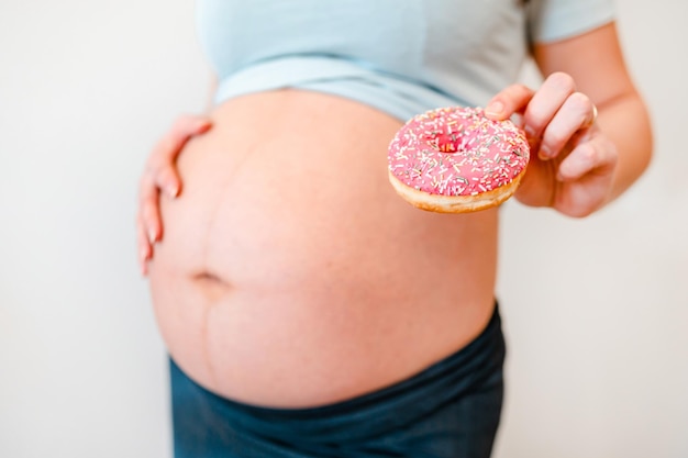 Mujer embarazada con un concepto de dieta de donas y diabetes mellitus gestacional en mujeres embarazadas