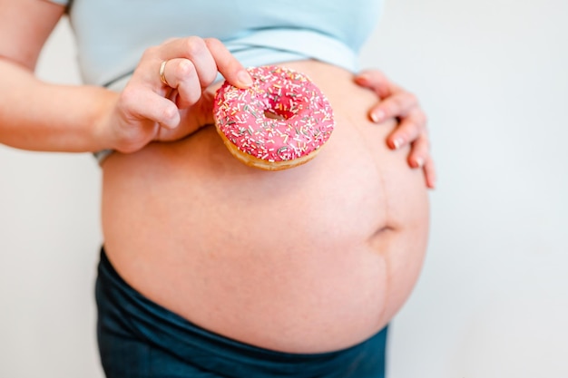 Mujer embarazada con un concepto de dieta de donas y diabetes mellitus gestacional en mujeres embarazadas