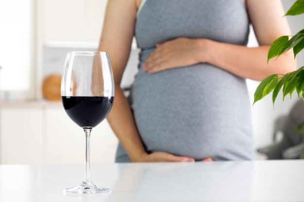 Mujer embarazada y copa de vino Embarazo y alcohol Cuidado prenatal y daño de malos hábitos