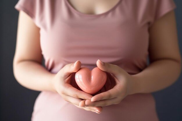 Foto mujer embarazada con corazón rosa en sus manos primer plano ai generativa