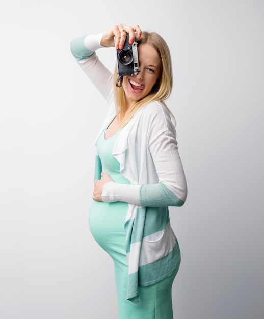 Mujer embarazada divertida tomando fotos