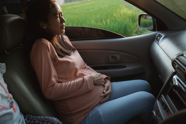 Mujer embarazada dolor de barriga durante el viaje en coche