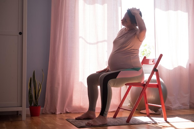 Mujer embarazada en entrenamiento de colchoneta de fitness en casa