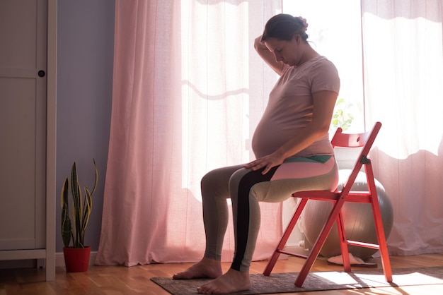 Mujer embarazada en entrenamiento de colchoneta de fitness en casa