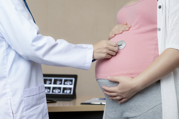 Foto mujer embarazada y ginecólogo médico en el hospital