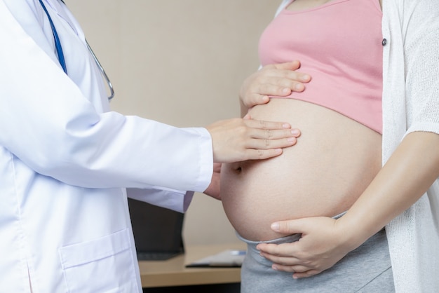 Foto mujer embarazada y ginecólogo médico en el hospital