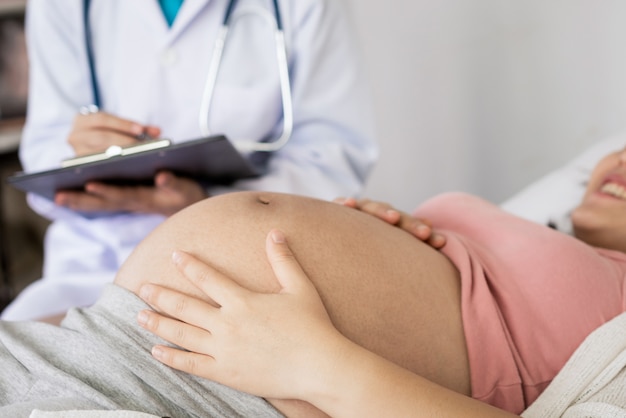 Foto mujer embarazada y ginecólogo médico en el hospital