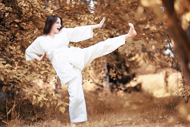 Mujer embarazada haciendo ejercicio de yoga en otoño