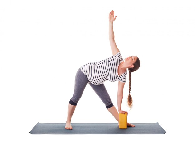 Mujer embarazada haciendo yoga asana Utthita trikonasana