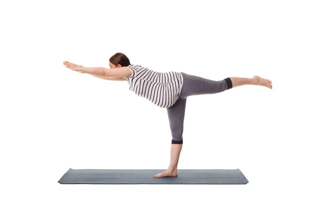 Mujer embarazada haciendo yoga asana virabhadrasana