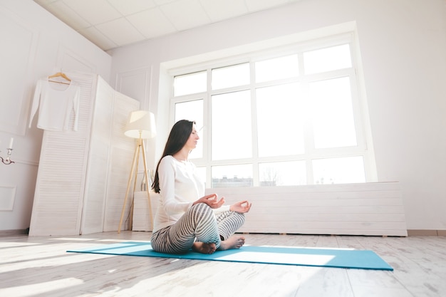 Mujer embarazada haciendo yoga en casa