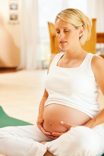 Mujer embarazada haciendo yoga embarazo
