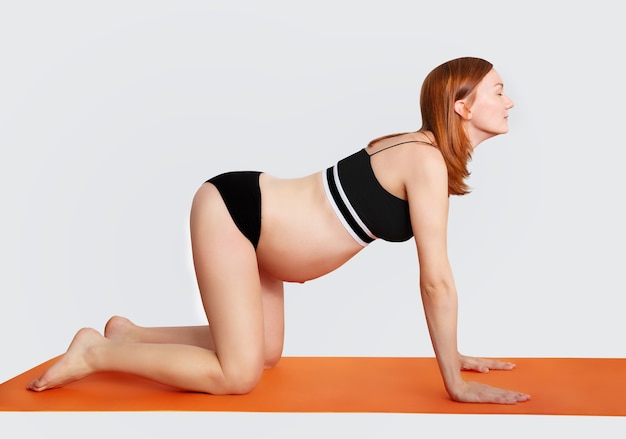 Mujer embarazada haciendo yoga y relajante