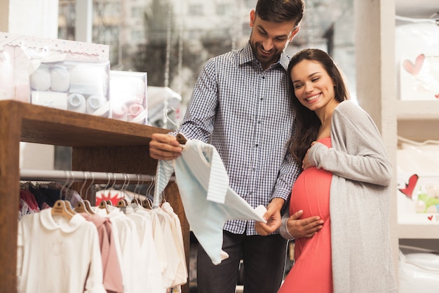 Una mujer embarazada con un hombre elige productos para bebés.