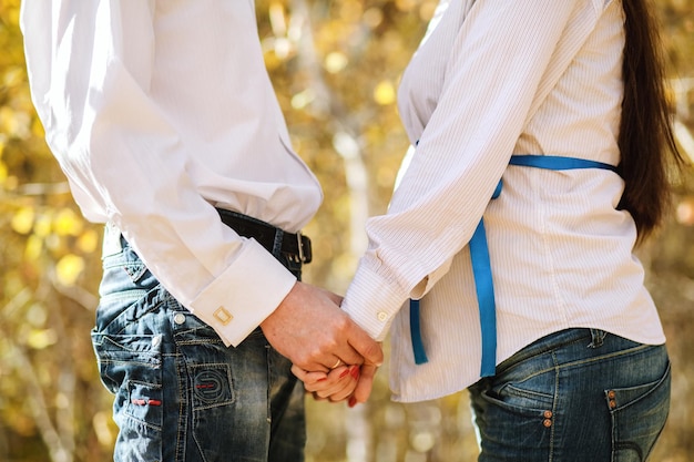 Mujer embarazada y hombre relajarse al aire libre Pareja embarazada en bosques de otoño