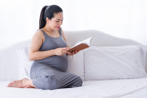 Mujer embarazada leyendo un libro.