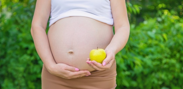 Mujer embarazada con una manzana en sus manos. Enfoque selectivo. comida.