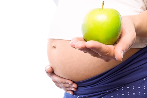 Mujer embarazada con manzana verde