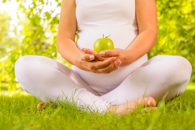 Mujer embarazada con manzana verde