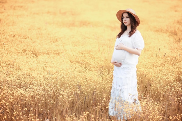 Mujer embarazada en la naturaleza a dar un paseo en el otoño