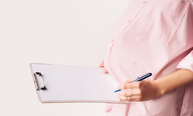 Mujer embarazada con papel blanco vacío como acuerdo de tarjeta médica en blanco Concepto de firmar contrato de vacunación papel de trabajo escribir plan de nacimiento Chequeo de atención médica durante el embarazo Plantilla para texto