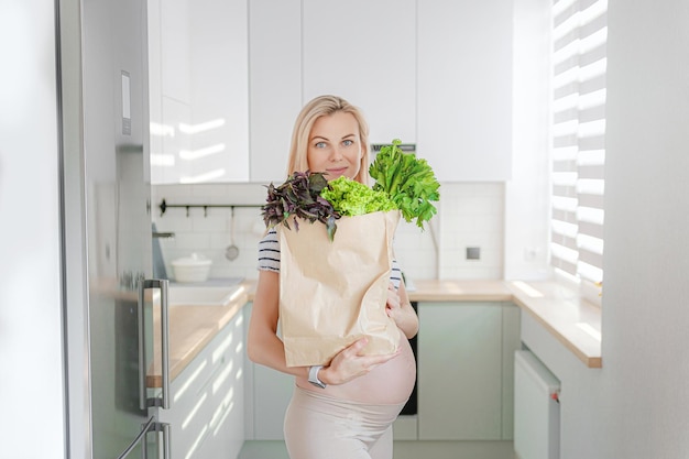 Mujer embarazada con paquetes de hierbas frescas batidos verdes el concepto de alimentos sanos y saludables para mujeres embarazadas