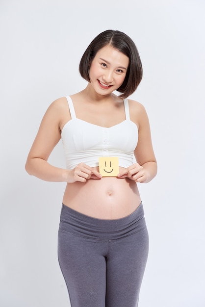 Mujer embarazada con pegatinas de papel en la barriga