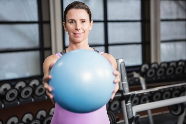 Mujer embarazada con pelota de ejercicios en el gimnasio