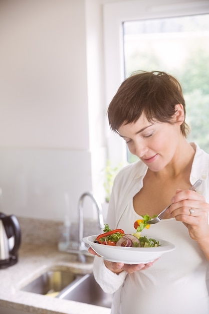 Mujer embarazada con plato de ensalada