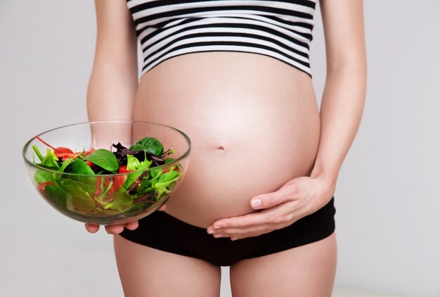 Mujer embarazada con un plato de verduras