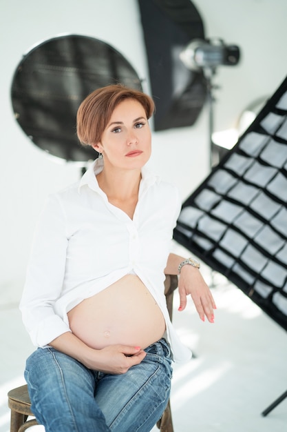 Foto mujer embarazada posa para sesión de fotos en estudio