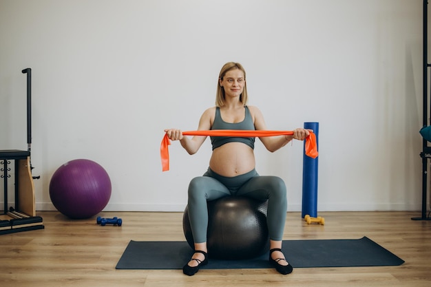 Mujer embarazada practicando yoga en casa