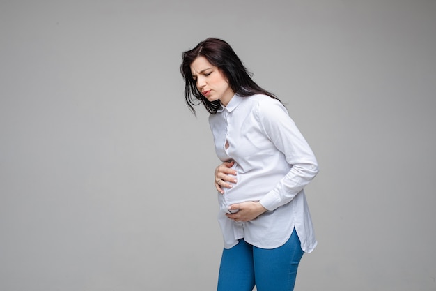 Mujer embarazada que tiene dolor en el vientre.