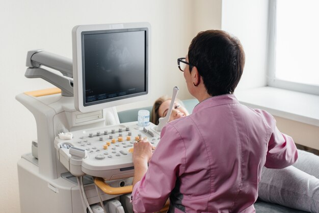 Una mujer embarazada recibe un ultrasonido de su abdomen en la clínica. Examen medico