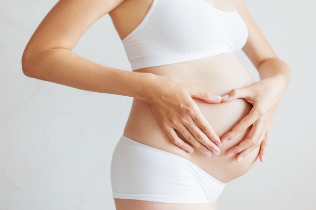 Mujer embarazada en ropa interior blanca