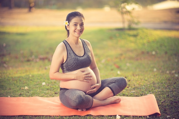 mujer embarazada sana haciendo yoga en la naturaleza al aire libre