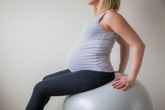 Mujer embarazada sentada en un fitball