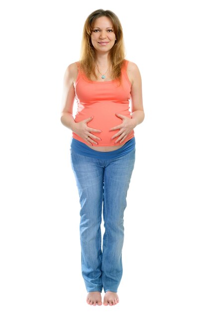 Una mujer embarazada sonriente en jeans