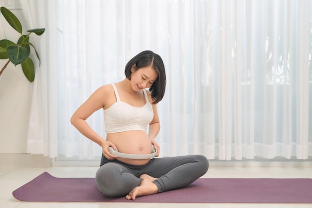 Mujer embarazada sosteniendo auriculares en su vientre Atención prenatal de maternidad y concepto de embarazo de la mujer