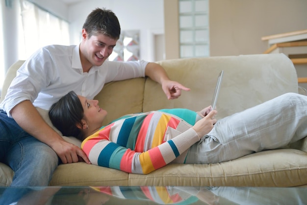 mujer embarazada con su esposo diviértase relájese y use tablet comture en casa moderna