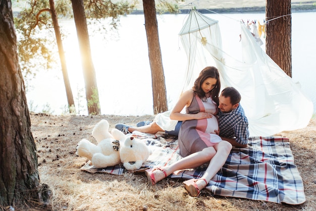 Mujer embarazada con su esposo en el picnic